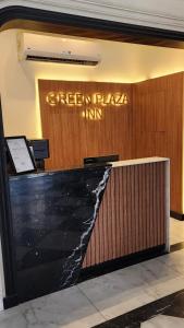 a green plaza inn sign on a wall in a lobby at Green Plaza Inn in Alexandria