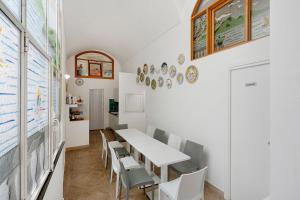 a dining room with a white table and chairs at Sorrentina Guest House in Sorrento