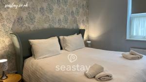 a bedroom with a bed with two towels on it at Eva's Sea View 2 Bed 2 Bath Parking in Kent
