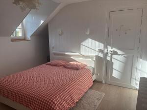 a bedroom with a bed with a red checkered blanket at Cine in Sainte-Menehould
