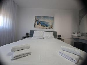 a bedroom with a white bed with towels on it at Tale Coast Apartments in Tale +107 photos