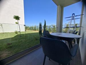 a patio with a table and chairs and a window at Tale Coast Apartments in Tale