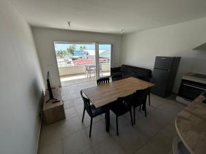 a living room with a wooden table and chairs at La Kaz Saint-Annaise in Sainte-Anne