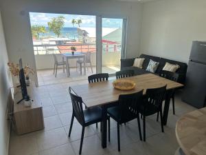 a living room with a wooden table and chairs at La Kaz Saint-Annaise in Sainte-Anne