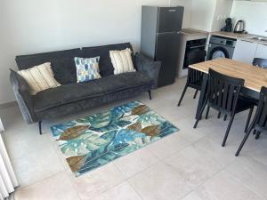 a living room with a couch and a table at La Kaz Saint-Annaise in Sainte-Anne +3 photos