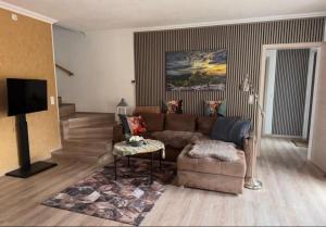 a living room with a couch and a tv at Ferienhaus Evelina in Steinheim