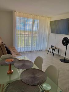 a living room with tables and chairs and a large window at Apartamento modero nuevo, 3 habitaciones y parqueadero en conjunto in Neiva