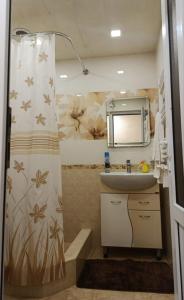 a bathroom with a sink and a shower curtain at Апартаменты in Jermuk +42 photos