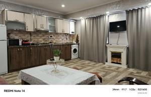 a large kitchen with a table and a fireplace at Апартаменты in Jermuk