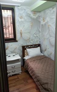a bedroom with a bed and a sink with butterflies on the wall at Апартаменты in Jermuk
