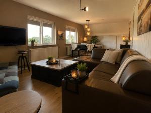 a living room with a couch and a table at Woonboerderij Markelo in Markelo