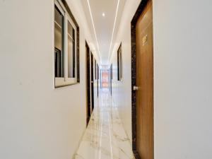 a hallway with white walls and a wooden door at Hotel O R.S in Nagpur