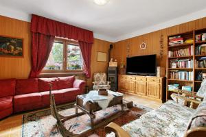 a living room with a red couch and a tv at Hotel Valentino - Bionaz in Bionaz