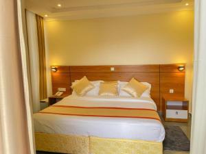 a bedroom with a large bed with a wooden headboard at VEGAS Motel in Kigali +29 photos