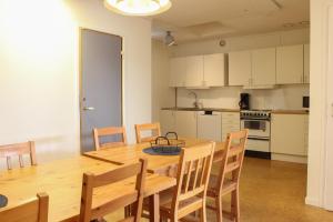 a kitchen and dining room with a wooden table and chairs at Ljusne Ice Camps in Ljusne