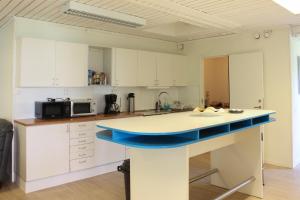 a kitchen with white cabinets and a blue island at Ljusne Ice Camps in Ljusne