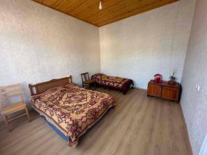 a bedroom with a bed and a table and a chair at Cozy home racha in Ambrolauri +3 photos