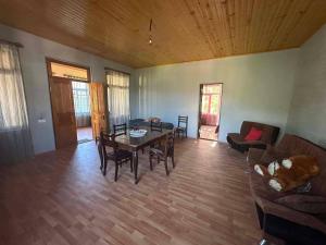 a living room with a table and a couch at Cozy home racha in Ambrolauri