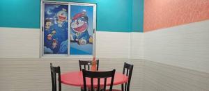 a red table and chairs in a room with a wall at Shravan Hotel in Rāmgarh