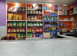 a grocery store with a counter and shelves of food at Shravan Hotel in Rāmgarh