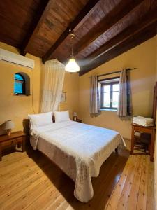 a bedroom with a large bed in a room with wooden floors at Velanos Villas in Kefálion +48 photos
