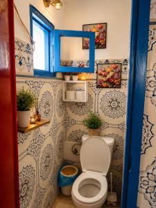 a bathroom with a toilet and a blue window at Tizaou Guest House in Taghazout +64 photos