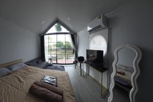 a bedroom with a bed and a large window at Grace Riverfront Villa Near Suvarnabhumi Airport in Lat Krabang