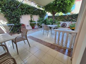 a patio with a table and chairs and plants at Olympic Studios Aslanidis in Olympic Beach