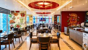 a dining room with tables and chairs in a restaurant at Oryx Hotel in Abu Dhabi