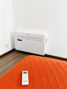 a remote control sitting on the floor next to a modem at Aveiro Ria View in Aveiro