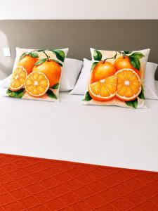 two pillows with oranges on them sitting on a bed at Aveiro Ria View in Aveiro +130 photos