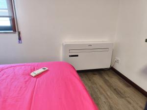 a remote control sitting on a bed in a room at Aveiro Ria View in Aveiro