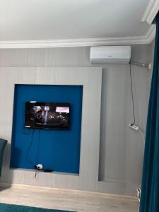 a room with a wall with a tv on a wall at Апартаменты на набережной 15 этаж in Astana