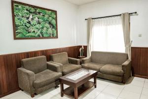a living room with two chairs and a coffee table at Melasti Kuta Beach Hotel & Spa in Kuta