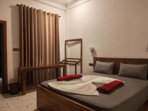 a bed with two red pillows on top of it at Elite Bay Arugambay in Arugam Bay
