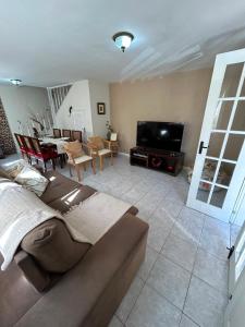 a living room with a couch and a flat screen tv at Cantinho na Serra in Teresópolis