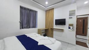 a bedroom with a bed and a tv on the wall at VRK Comfort in Mysore