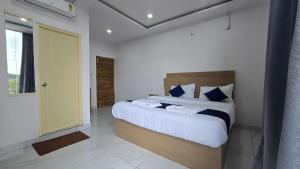 a bedroom with a large bed and a yellow door at VRK Comfort in Mysore +2 photos