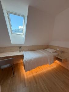 a bedroom with a white bed and a window at Apartment House Belca in Preddvor