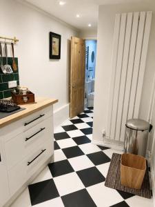 a kitchen with a black and white checkered floor at Little B - Artist owned boutique apartment near Southsea beach in Portsmouth