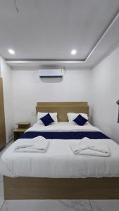a bedroom with a large bed with blue pillows at VRK Comfort in Mysore