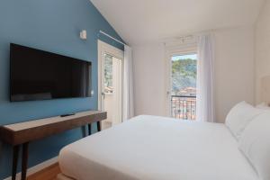 a bedroom with a bed and a flat screen tv at Portopiccolo Apartments Deluxe in Sistiana +111 photos