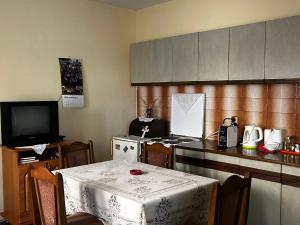a kitchen with a table and a kitchen with a table and a television at Sremac in Kupinovo +5 photos