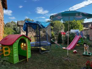 a playground with a play set and an umbrella at Sremac in Kupinovo