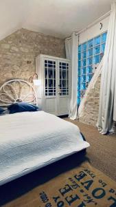 a bedroom with a bed and a stone wall at La Closerie Teranga in Bayeux +87 photos