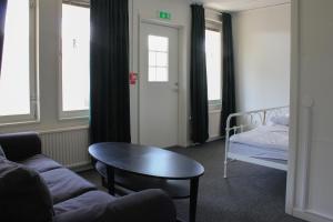 a living room with a couch and a table and a bed at Ljusne Ice Camps in Ljusne +9 photos
