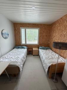 two beds in a small room with a window at Country House Marja 
