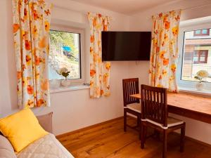 a living room with a table and two chairs and a television at Ferienwohnung Mondseeblick in Tiefgraben