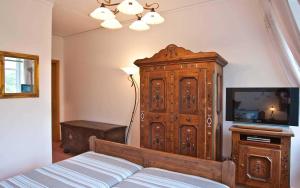 a bedroom with a large wooden cabinet next to a bed at Ferienzimmer Günther Objekt 28985 in Rostock +9 photos