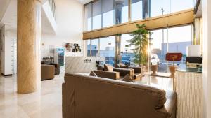 a lobby with a couch and chairs and windows at توارن للشقق المخدومة - اقتصادي in Hail